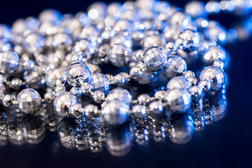White pearl necklace isolated on black blue background.