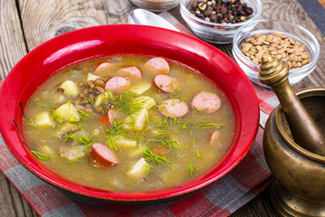 Soup of green lentils in a red ceramic bowl