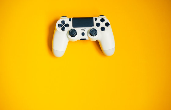 Computer game competition. Gaming concept. White joystick on yellow background.