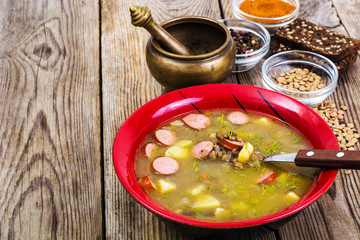 Soup of green lentils in a red ceramic bowl