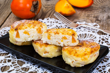 Cottage cheese pancakes with slices of persimmon for breakfast