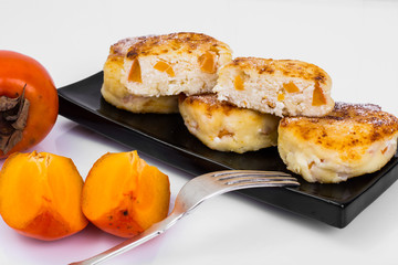 Cottage cheese pancakes with slices of persimmon for breakfast