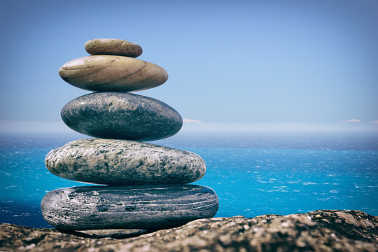Zen Balancing Pebbles on Beach on sea background