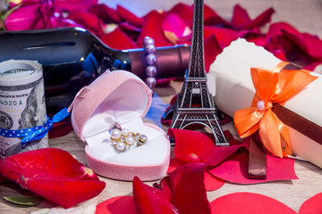 holiday concept - roses petals, money, bottles of wine, a box of jewels and Eiffel Tower.