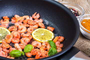 Small shrimp with lemon in a frying pan