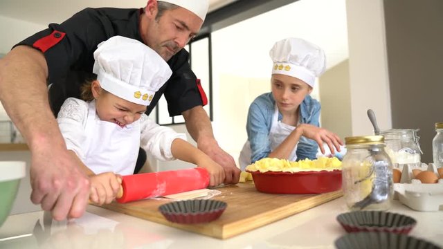 Little girl in pastry class with teacher and mates