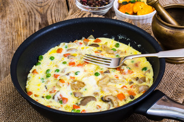 Omelet with vegetables in a pan