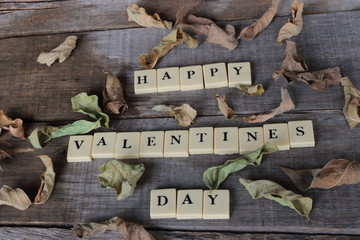 Happy Valentines day wording by crossword on old wooden board background