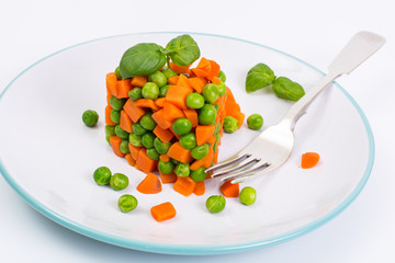 Mix orange carrots and green peas with olive oil and curry