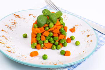 Mix orange carrots and green peas with olive oil and curry
