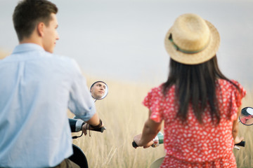 Happy young couple in love on retro motorbike driving togetger and ejoying the trip near the ocean.