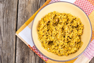Side dish of lentils with vegetables, butter in bowl on wooden b
