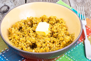 Side dish of lentils with vegetables, butter in bowl on wooden b