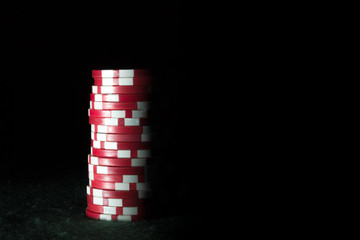 Stack of red poker chips on a dark background