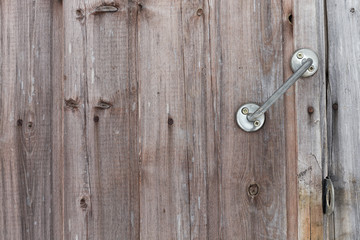 Closed and unlocked wooden old door with handle, lock eyelets and nail heades