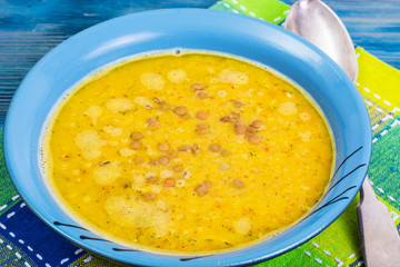 Thick soup of green lentils with curry on a blue background