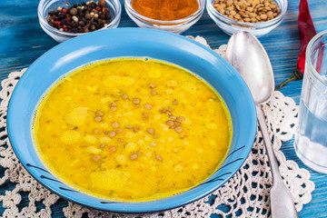 Thick soup of green lentils with curry on a blue background