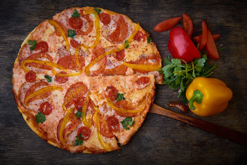 Pizza and different ingredients in it. Dark background. View from above. Studio photography, Subject photography.
