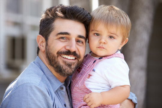 Outdoor Portrait Of Father Holding Son