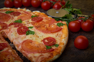 Pizza and different ingredients in it. Dark background. View from above. Studio photography, Subject photography.