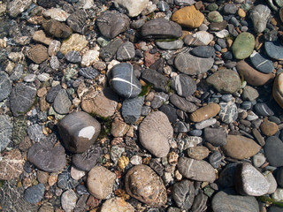 Stones in a river with reflections from the water and nice forms