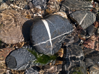 Stones in a river with reflections from the water and nice forms