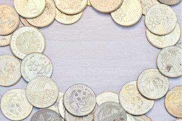 Frame of coins with copy space on centre with wooden background.