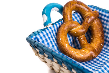 Sweet pretzels on a beautiful fabric in a wicker basket on a whi