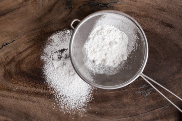 Wheat flour in a sieve on wooden background,food ingredient,prepare for cooking or baking