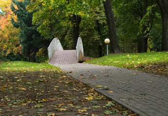 alley and  bridge in park at autumn day