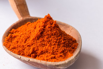Red pepper powder in wooden spoon