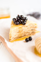 Homemade pancakes with berries and honey on a white background