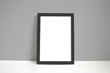 Black portrait frame against grey wall