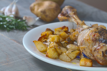 Homemade bakery leg lamb and potaoes. Background: rosemary, garlic and potatoes.