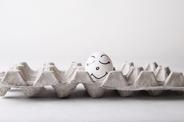 Chicken egg with a pretty funny face in a box on a white background.  Easter Concept Photo. Eggs....