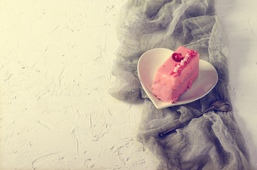 Pink cupcakes, spoon under morning sun on grey runner and white background. Toned effect