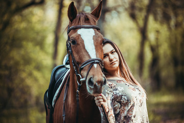 Fototapeta premium Young girl with a horse in the forest.