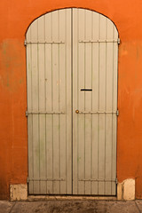 Puerta de madera en fachada de color caldero.