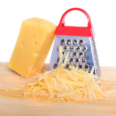 Bar cheese grater and grated cheese on cutting board isolated