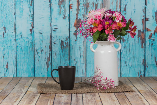 Bouquet of flowers in vintage white vase in rustic setting with