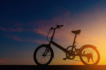Fototapeta na wymiar Silhouette bicycle on dramatic sky at sunset.