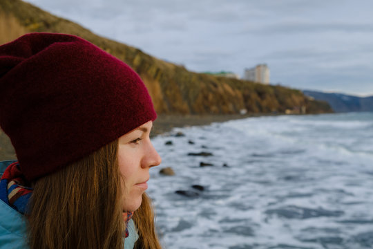 young woman looks at the stormy sea