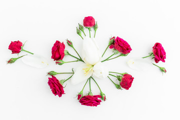 Valentines Day background. Floral pattern made red roses, tulip petals and branches on white background. Flat lay, top view.