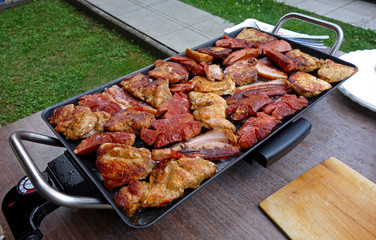 Different kinds of meat is baked on electric grill