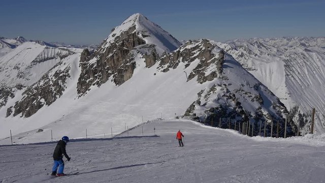 Skiers and snowboarders on on the slopes of high mountains