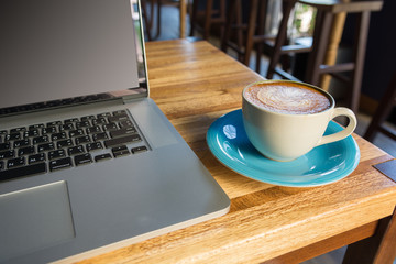 Working with laptop and coffee cup on wooden table