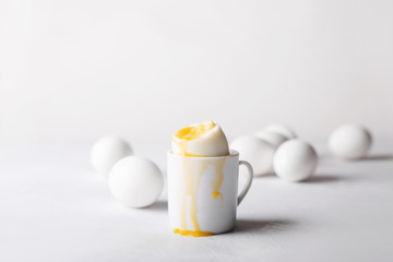 Boiled egg in a small cup on a white background. Eggs. Breakfast. Easter photo concept. Copyspace