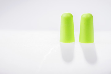 Two green ear plugs isolated on white background