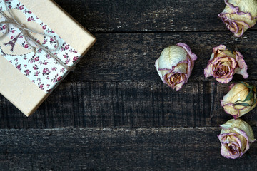 Fototapeta na wymiar white pink dried roses on wooden table