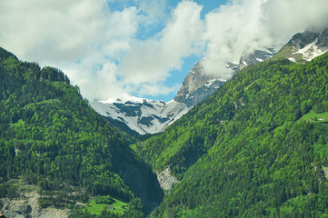 Fototapeta premium Green mountains and clouds in Switzerland